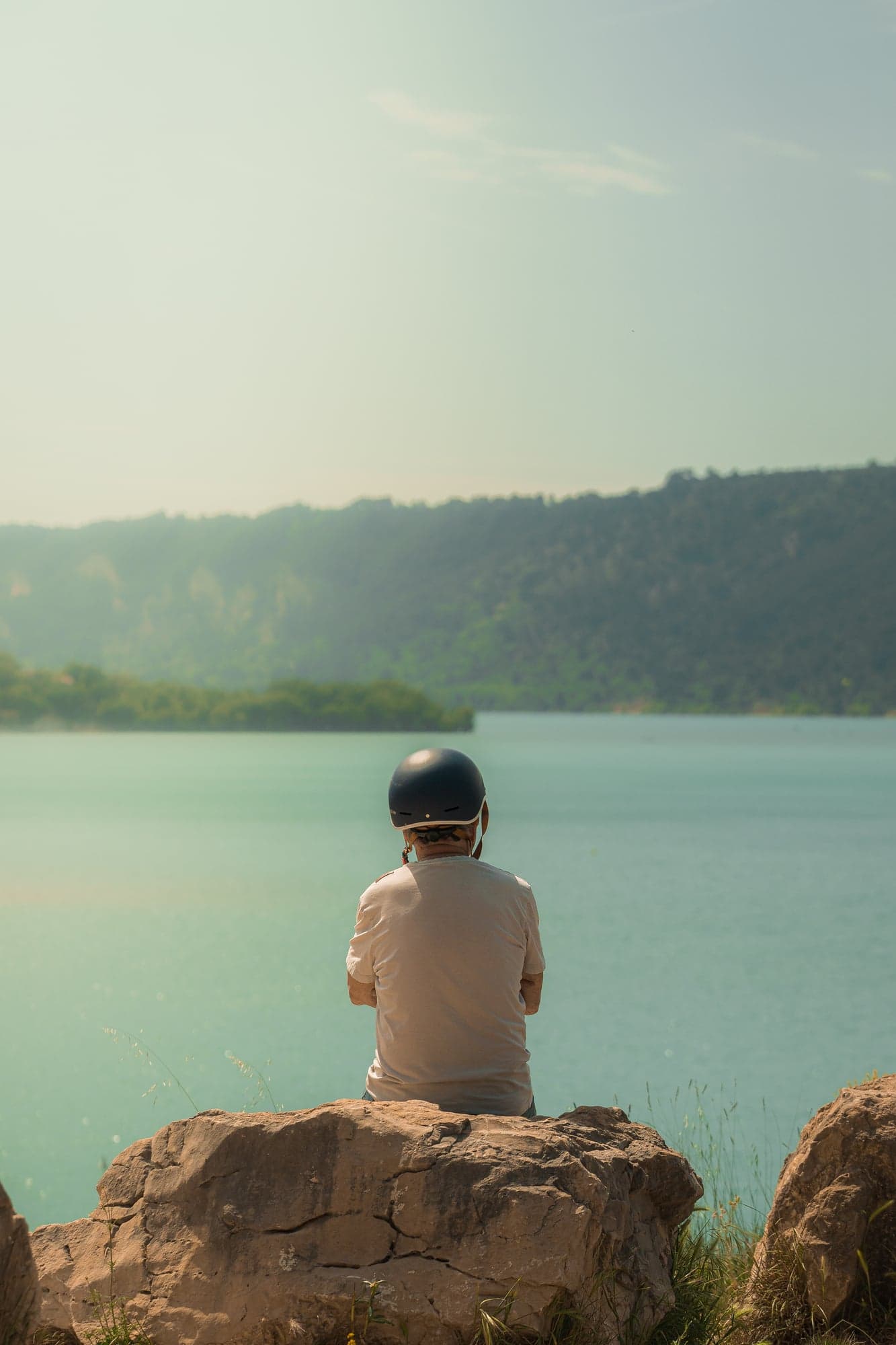 A silhouette facing a mountain lake
