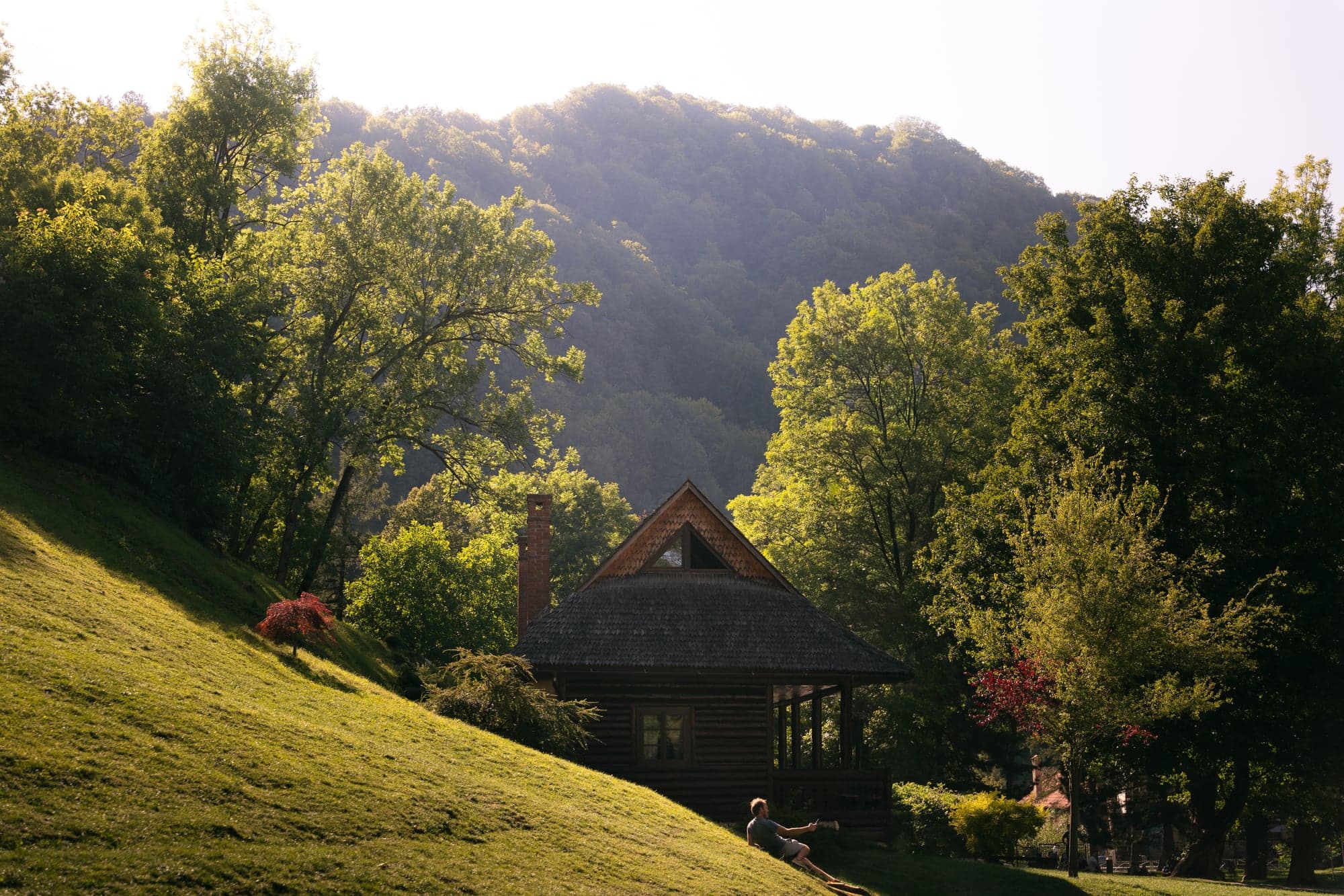 A wooden chalet at the foot of the mountains, evening light
